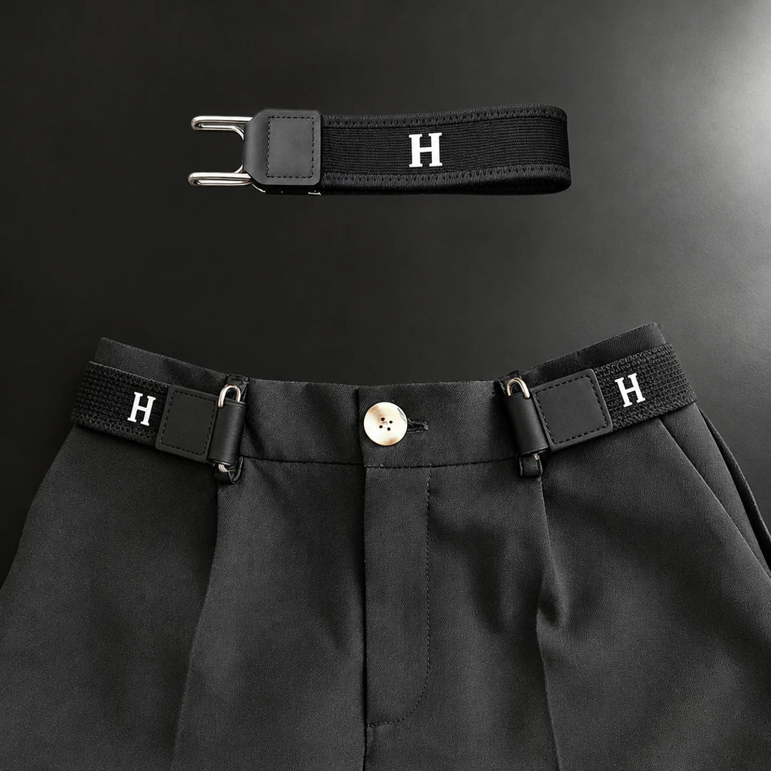Zwarte gesploze riem aan weerszijden van de knoopsluiting van een nette pantalon, met een los exemplaar erboven